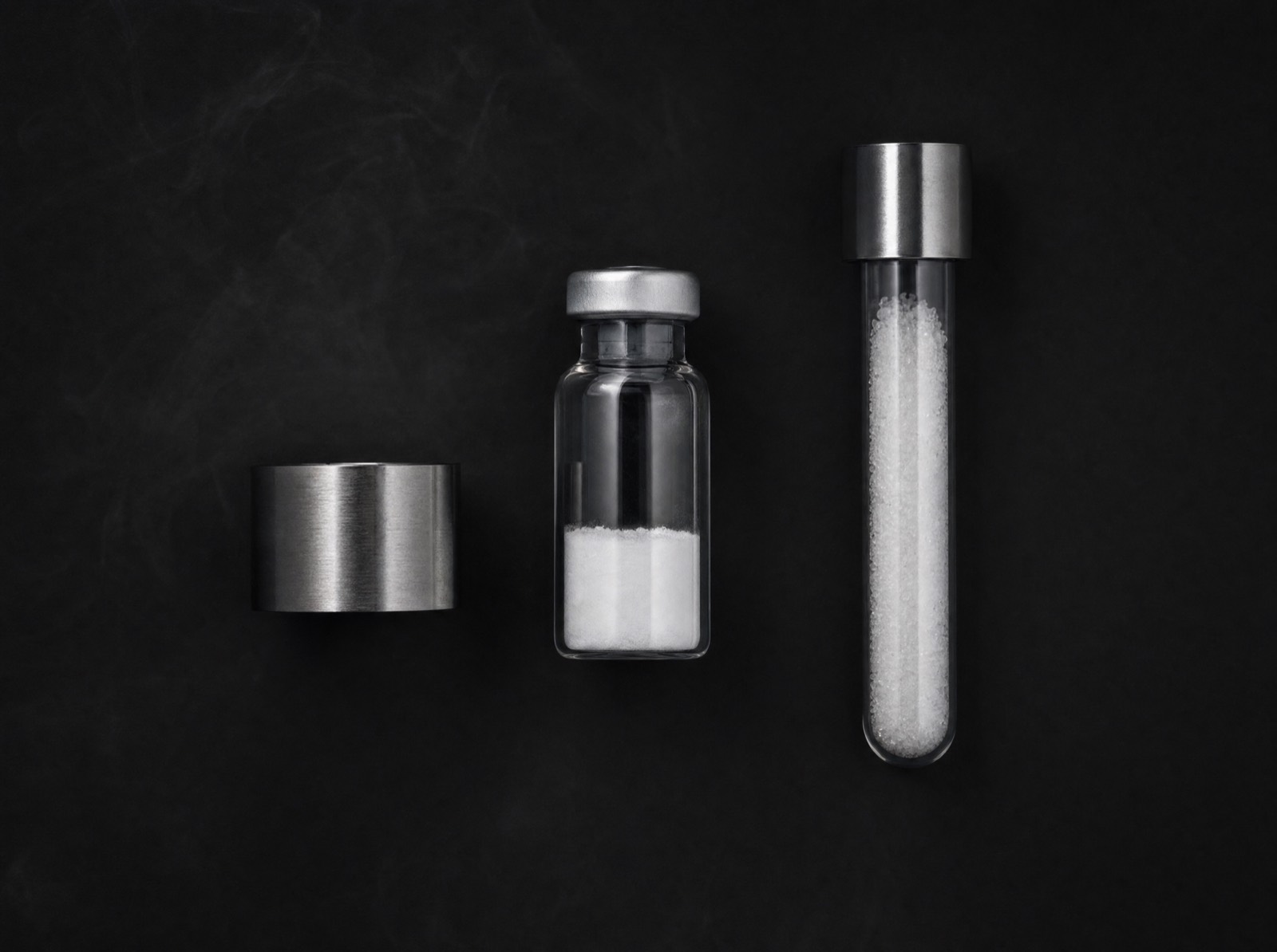Sealed lyophilized vial and sample tube on dark slate
